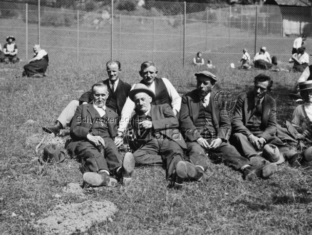 Ausflug von arbeitslosen Holzarbeitern nach Wildpark - Männer im Gras sitzend