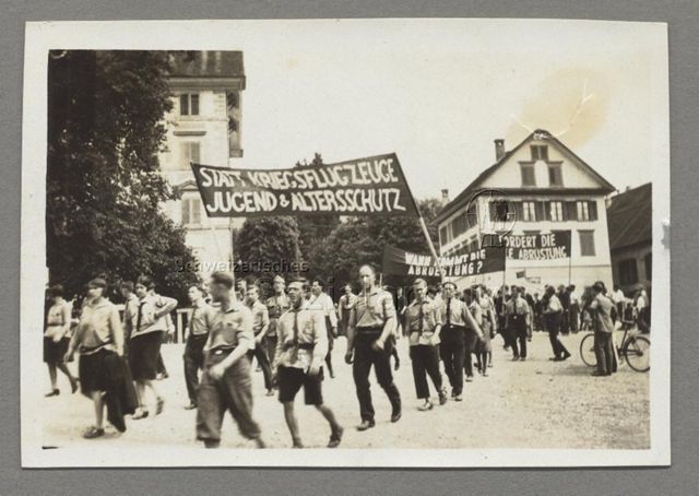Die Sozialistische Arbeiterjugend SAJ am sozialistischen Jugendtag in Zug, Transparente "Statt Kriegsflugzeuge Jugend- und Altersschutz", "Wann kommt die Abrüstung", "Fordert die [totale?] Abrüstung", 1930