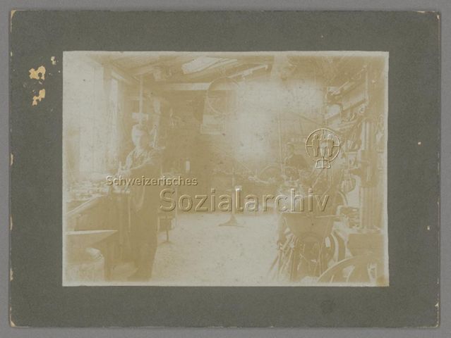 Arbeiter in mechanischer Fahrradwerkstätte, Plakat an Wand "Neckarsulmer Fahrradwerke A.G.