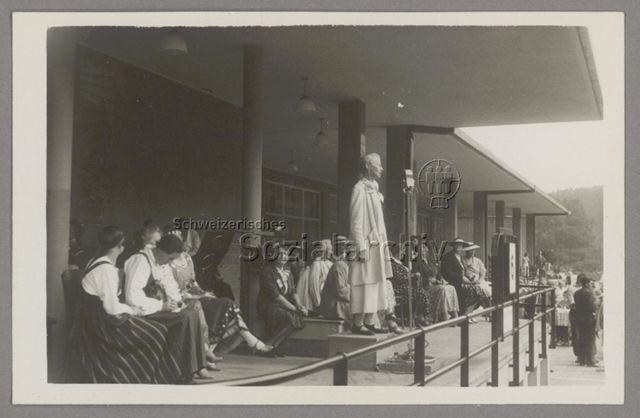 Lida Gustava Heymann auf Podest und mit Mikrophon bei Rede im Rahmen des Kongresses der Internationalen Frauenliga für Frieden und Freiheit (IFFF/WILPF) in Prag, 1929